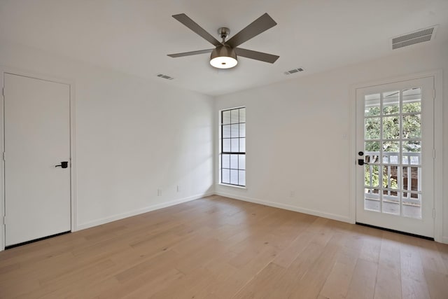 unfurnished room with a ceiling fan, light wood-style flooring, visible vents, and baseboards