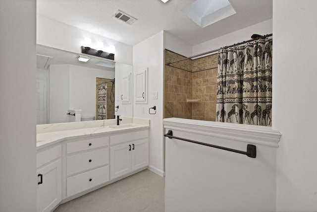 bathroom with tiled shower, a sink, visible vents, and double vanity