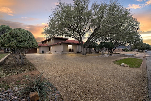 view of front of house featuring curved driveway and stucco siding