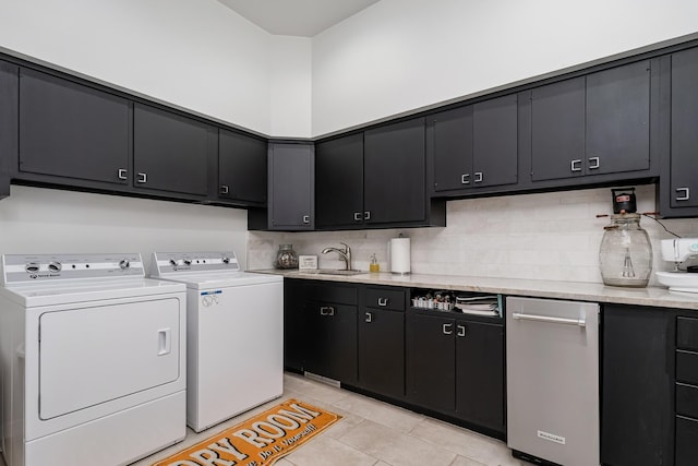 clothes washing area with cabinet space, independent washer and dryer, a sink, and light tile patterned flooring