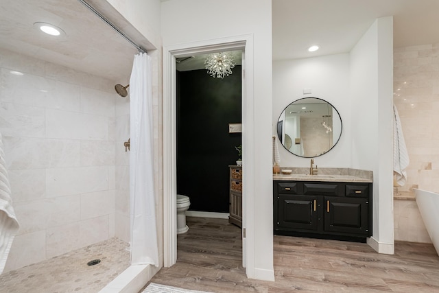 bathroom featuring a tile shower, vanity, and wood finished floors