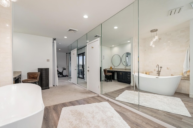 full bath featuring a freestanding bath, visible vents, and recessed lighting