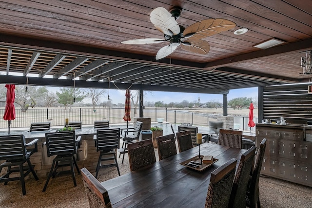 view of patio featuring ceiling fan, outdoor dining area, and fence