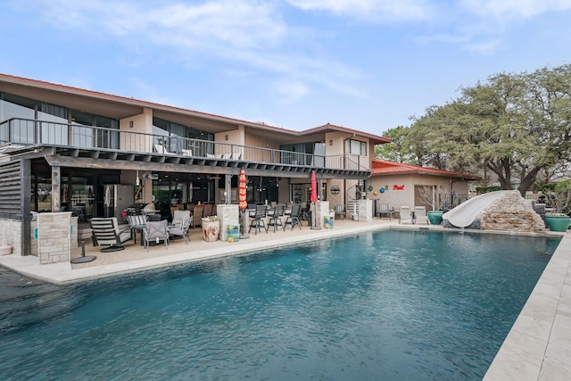 pool with a patio and a water slide