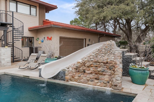 exterior space with stairs, a water slide, and a patio area