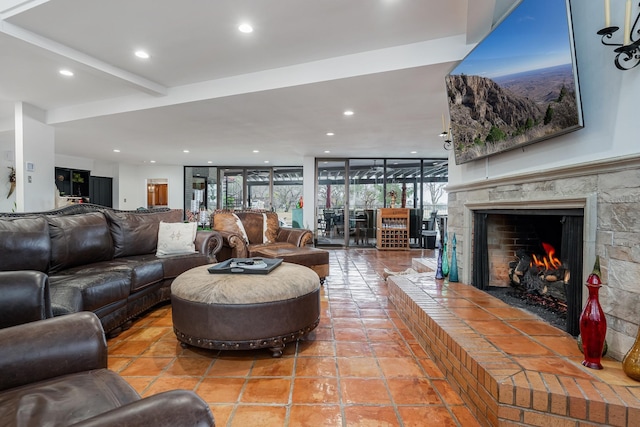 tiled living area featuring recessed lighting and a warm lit fireplace