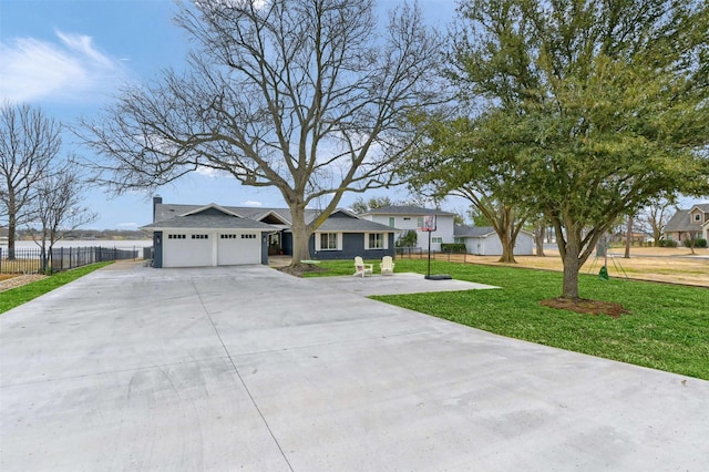 ranch-style home with a garage, fence, concrete driveway, and a front yard