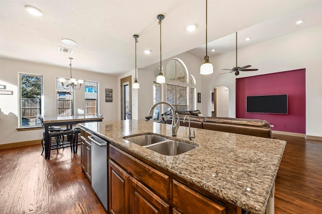 kitchen with visible vents, stainless steel dishwasher, a sink, arched walkways, and dark wood-type flooring