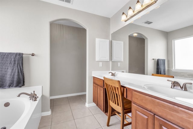 full bath featuring double vanity, visible vents, tile patterned floors, a garden tub, and a sink