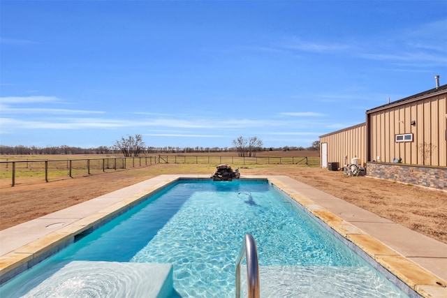 outdoor pool with a fenced backyard and a rural view