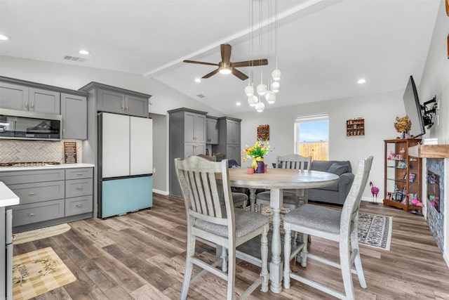 dining room featuring vaulted ceiling with beams, recessed lighting, visible vents, a ceiling fan, and wood finished floors