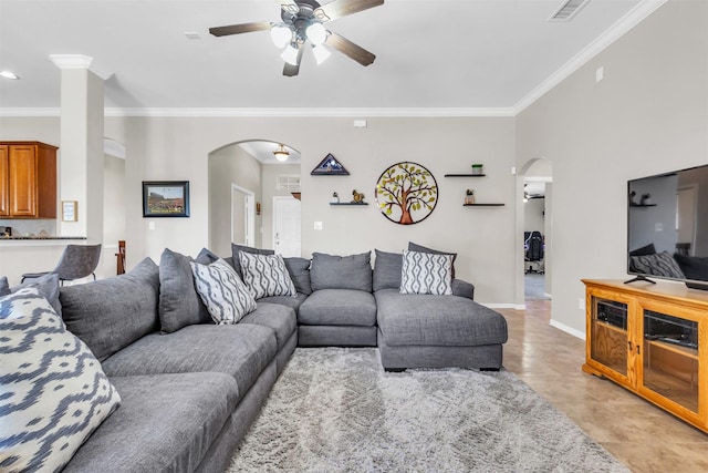 living area featuring ornamental molding, arched walkways, visible vents, and baseboards