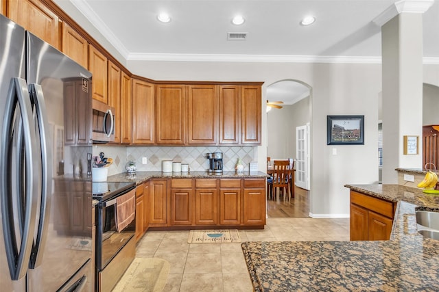 kitchen featuring light tile patterned floors, stainless steel appliances, visible vents, brown cabinets, and crown molding