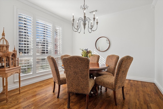 dining room with an inviting chandelier, plenty of natural light, ornamental molding, and wood finished floors