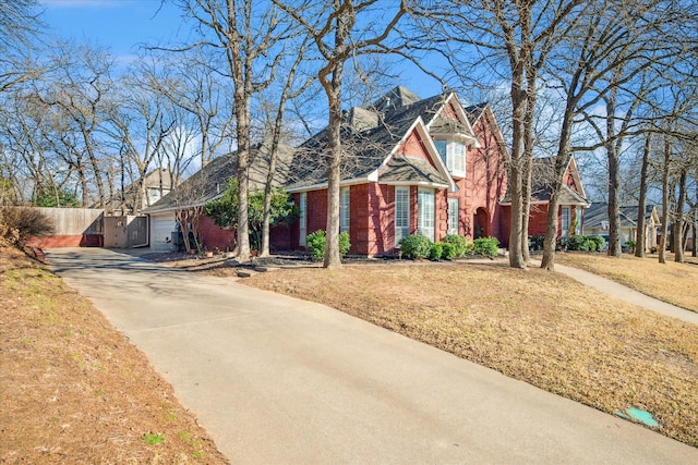 view of front of house with a front yard, brick siding, and fence