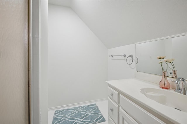 bathroom with lofted ceiling and vanity