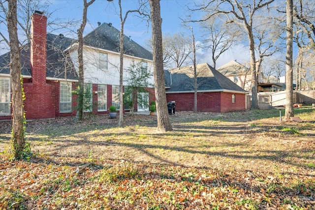 back of property with a chimney and brick siding