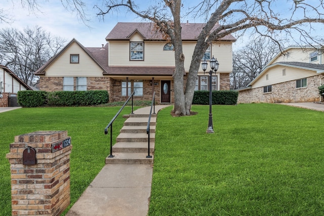 view of front of house with brick siding, a front yard, and a shingled roof