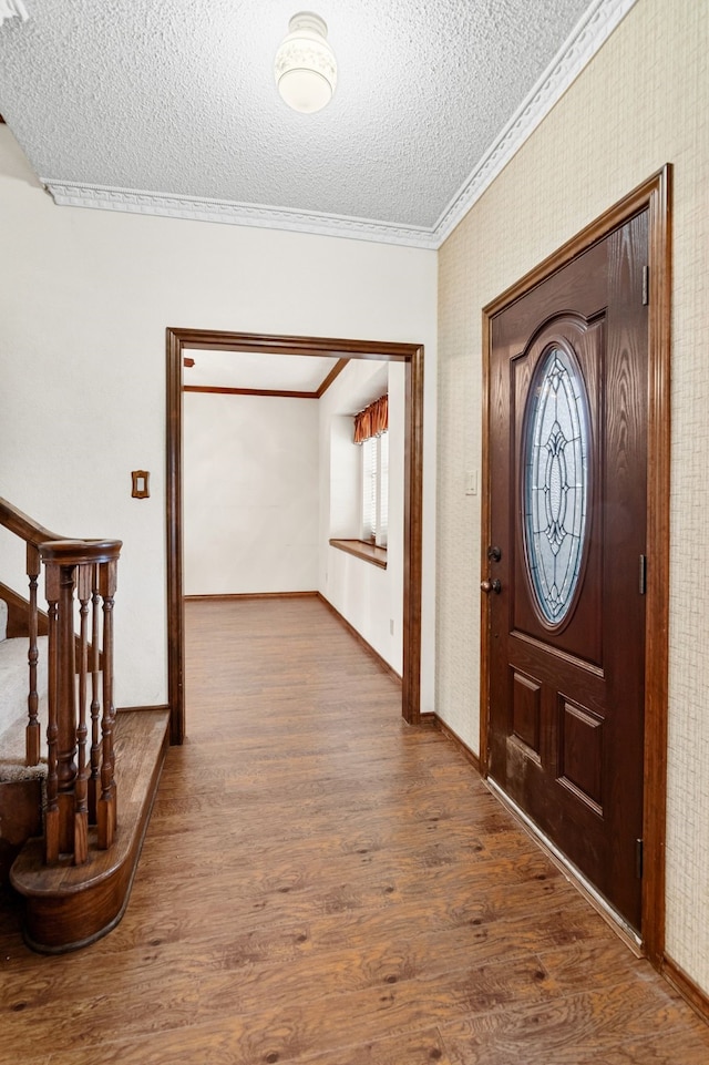 entryway featuring a textured ceiling, dark wood-type flooring, stairs, and crown molding