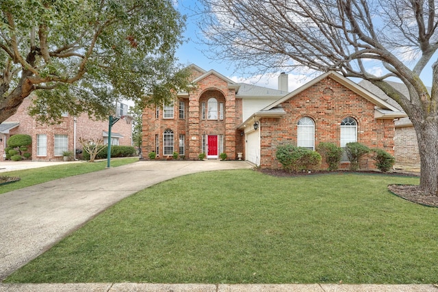 traditional-style home with driveway, a chimney, an attached garage, a front lawn, and brick siding