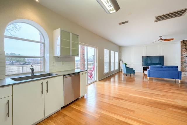 kitchen with decorative backsplash, visible vents, a sink, and stainless steel dishwasher