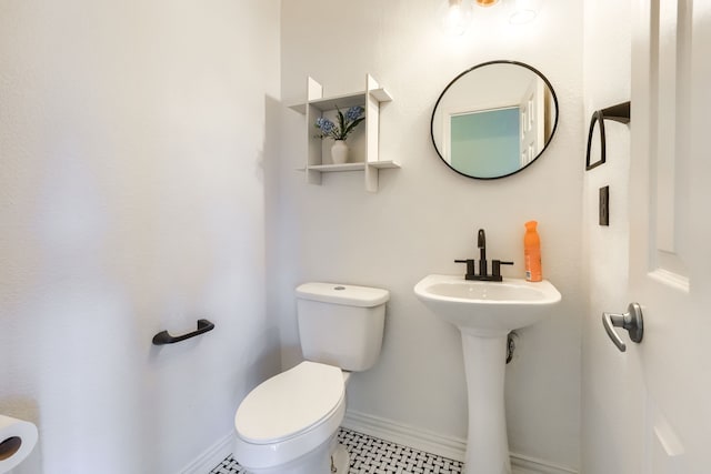 half bathroom with toilet and baseboards