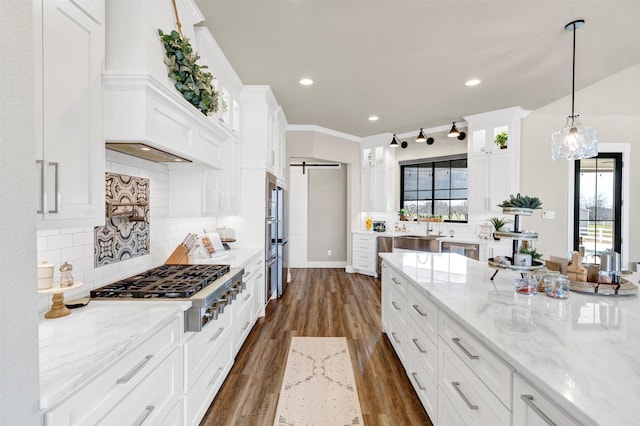 kitchen featuring dark wood-style flooring, decorative backsplash, a barn door, appliances with stainless steel finishes, and white cabinets