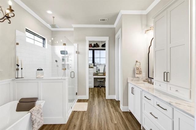 bathroom featuring a shower stall, visible vents, wood finished floors, and ornamental molding