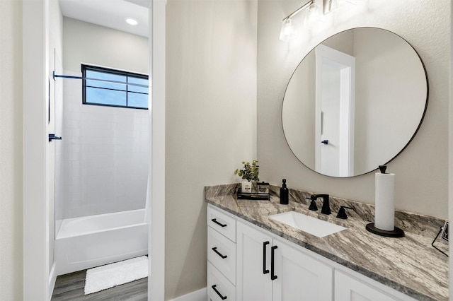 bathroom featuring shower / tub combination, wood finished floors, and vanity