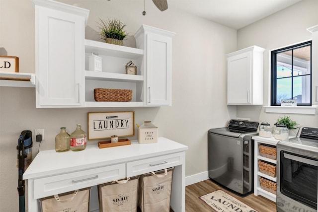 laundry area featuring cabinet space, baseboards, a ceiling fan, wood finished floors, and washer and dryer