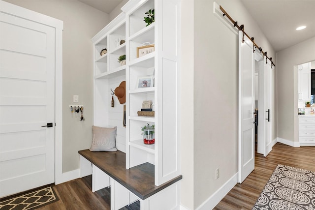 mudroom featuring a barn door, baseboards, dark wood finished floors, and recessed lighting