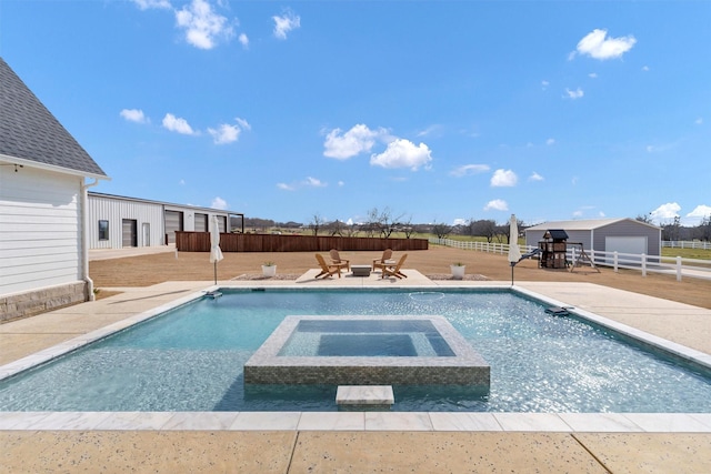 view of swimming pool with a patio area, a fenced backyard, a pool with connected hot tub, and an outdoor structure