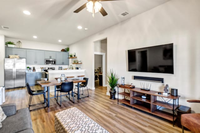 living room featuring ceiling fan, light wood-type flooring, visible vents, and recessed lighting