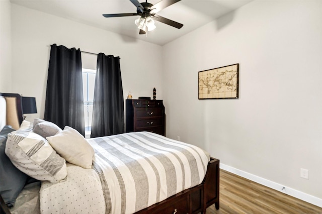 bedroom featuring ceiling fan, baseboards, and wood finished floors