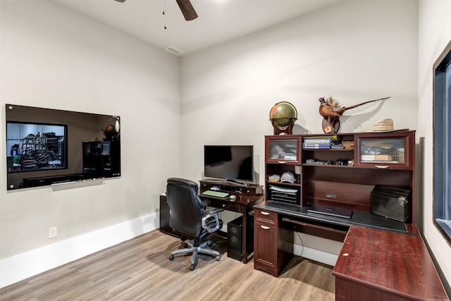 office featuring baseboards, a ceiling fan, visible vents, and light wood-style floors