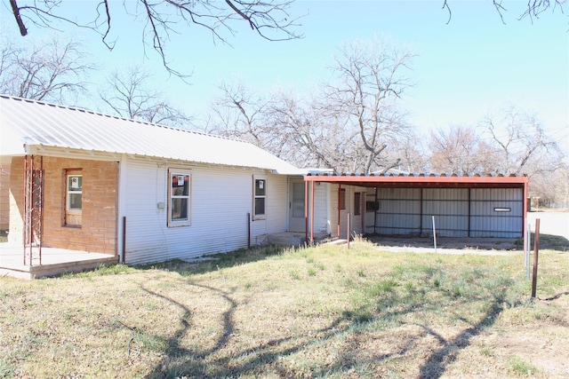 view of front facade with metal roof and a front lawn