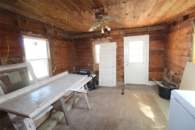 interior space featuring wooden ceiling, ceiling fan, wooden walls, and wood finished floors