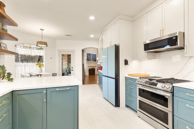 kitchen featuring appliances with stainless steel finishes, light countertops, visible vents, and open shelves