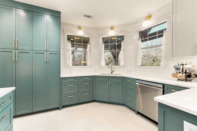 kitchen featuring dishwasher, light countertops, a sink, and green cabinetry