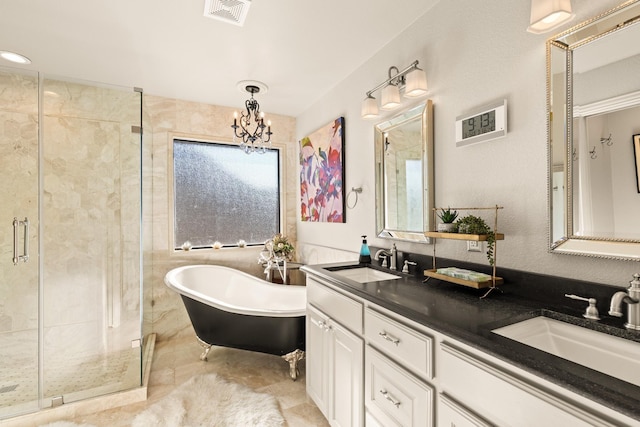 bathroom with a freestanding tub, a stall shower, a sink, and visible vents