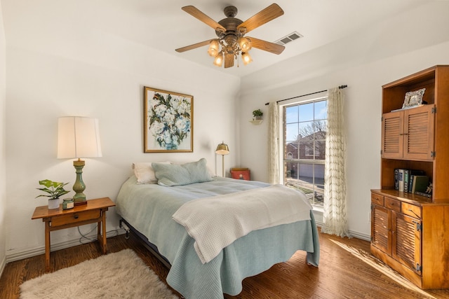 bedroom with light wood-style floors, visible vents, baseboards, and a ceiling fan