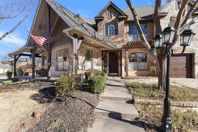 view of front of property with a garage, brick siding, and a shingled roof