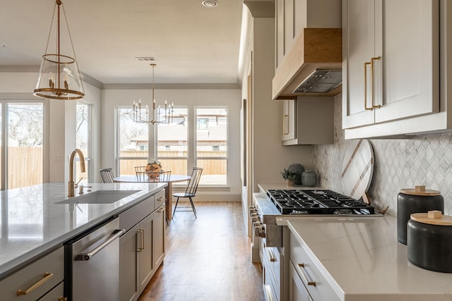 kitchen with stove, a sink, visible vents, dishwasher, and wall chimney exhaust hood