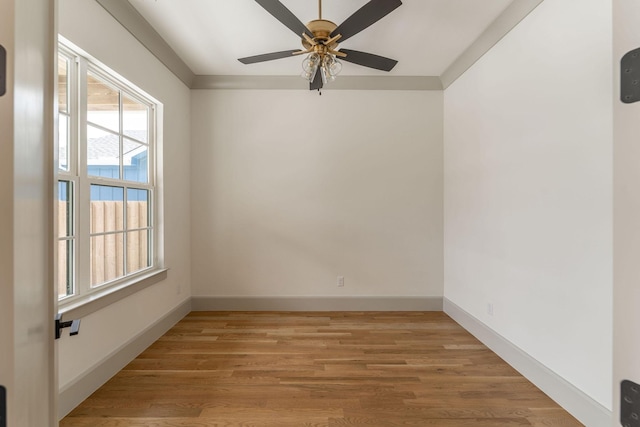 empty room featuring light wood-type flooring, baseboards, and a ceiling fan