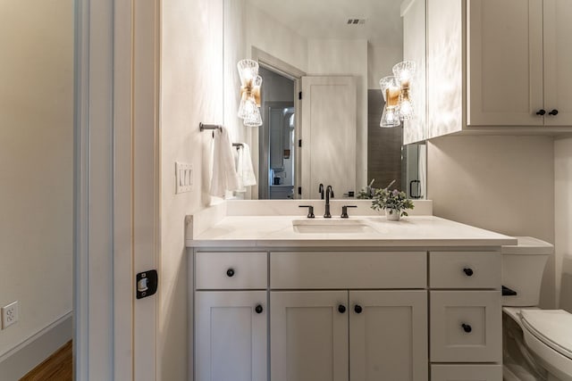 bathroom with visible vents, vanity, and toilet