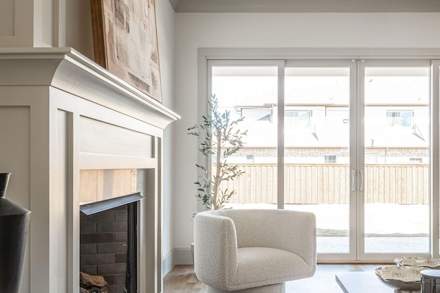 sitting room with a fireplace and light wood-style flooring