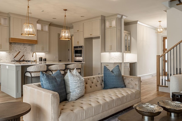 living room with baseboards, stairway, and light wood finished floors