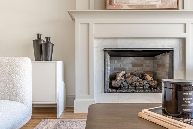 interior details with a tiled fireplace and wood finished floors