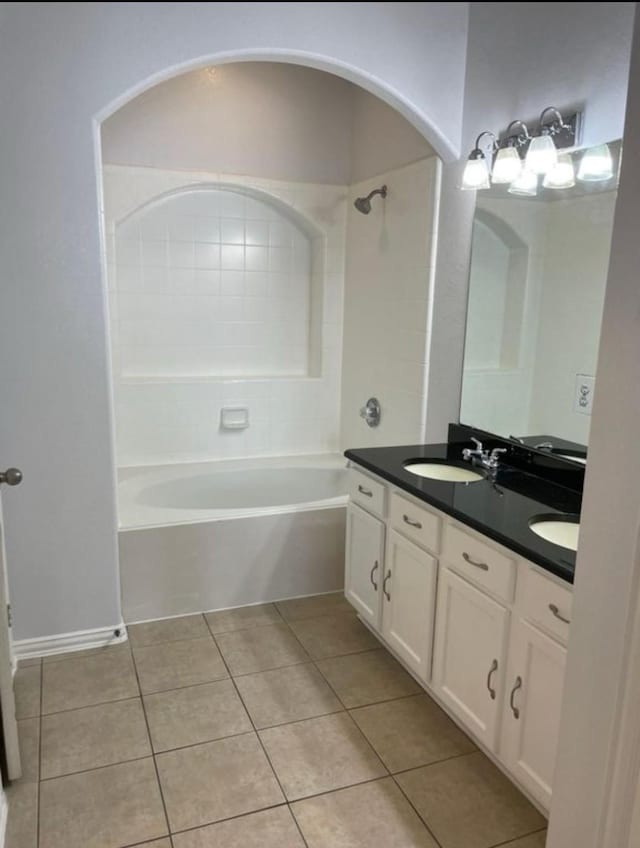 bathroom with double vanity, shower / tub combination, a sink, and tile patterned floors