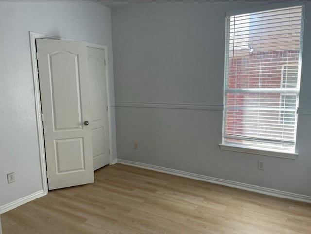 empty room with light wood-style flooring and baseboards